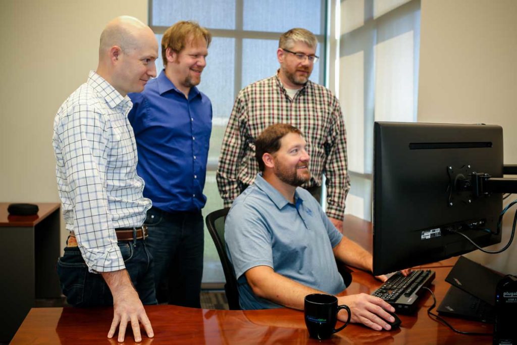 Netsuite for Ecommerce - group of men viewing a pc monitor