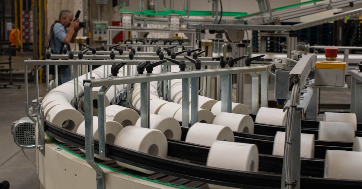 Photographer captures a production line for toilet paper in an industrial setting.