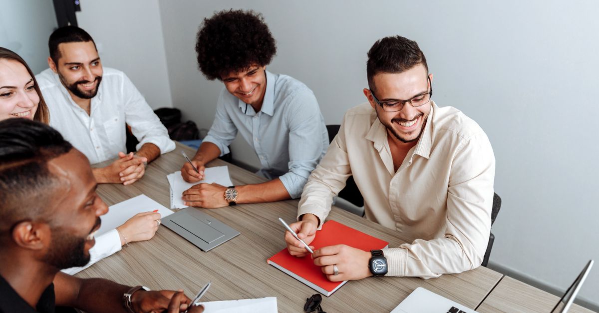 A group of diverse professionals collaborating during a team meeting in a modern office setting.