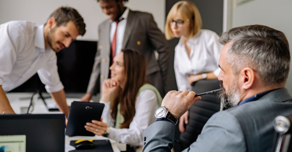 A diverse group of professionals engaging in a collaborative meeting in a modern office setting.