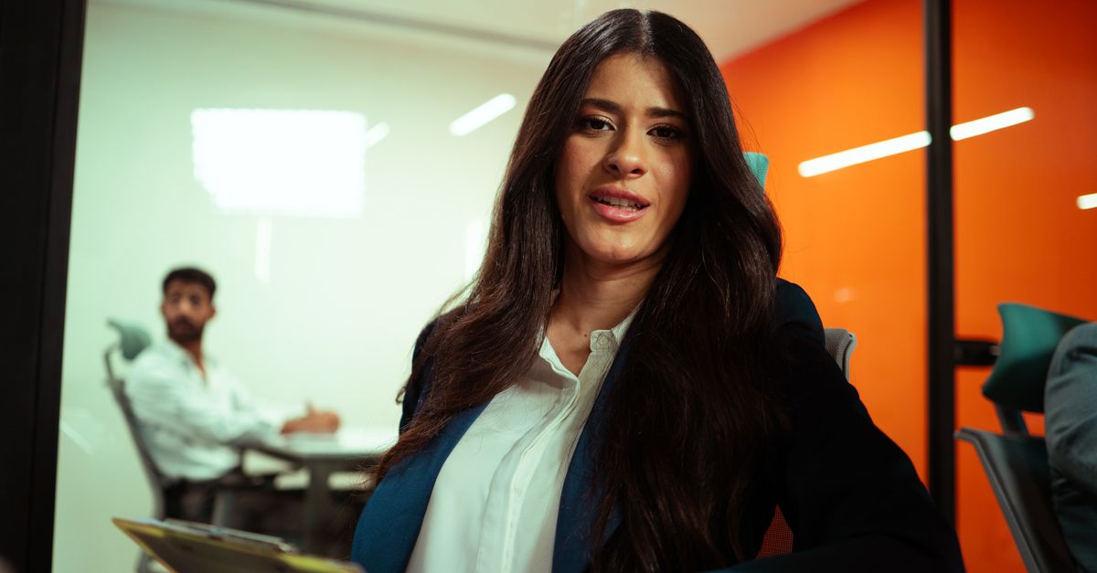 Professional woman in a modern office environment engaging in a business meeting.