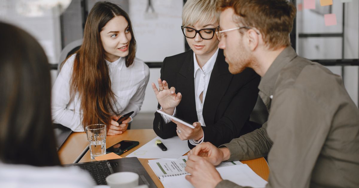 Professional team collaborating in a modern office meeting room, discussing strategies.