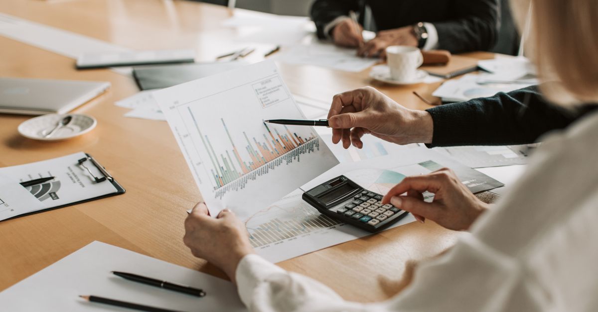 Professionals reviewing financial graphs and charts during a meeting.