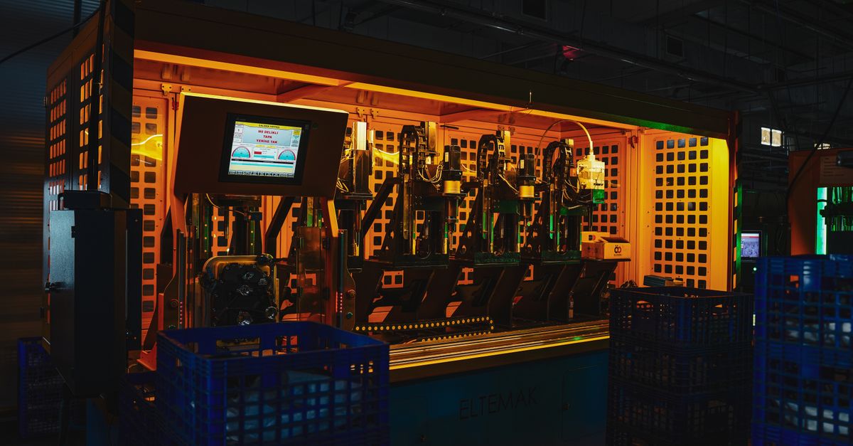 A complex piece of machinery in a dark industrial setting with vibrant lighting.