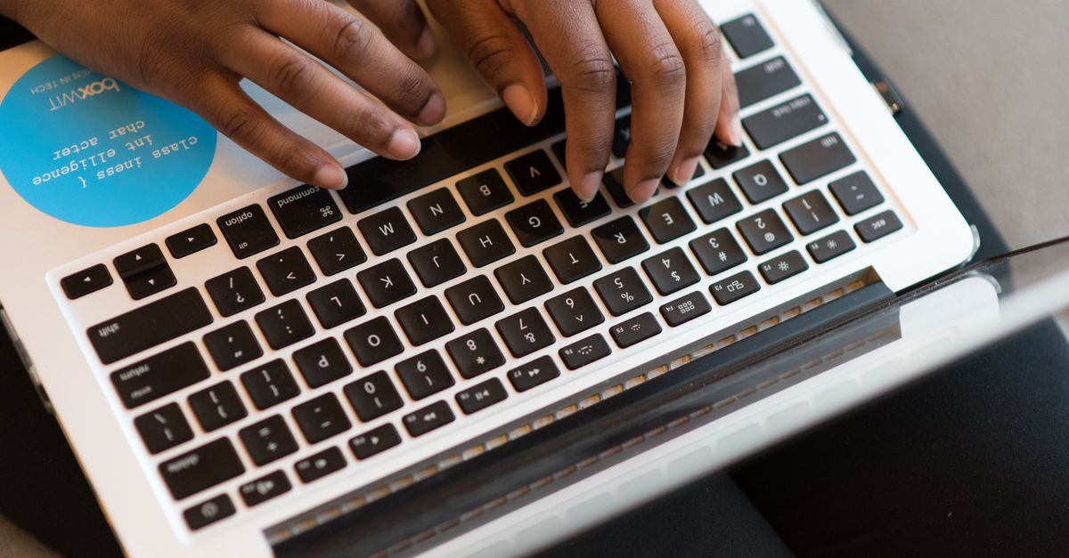 Close-up of hands typing on a laptop, showcasing modern technology and connectivity.