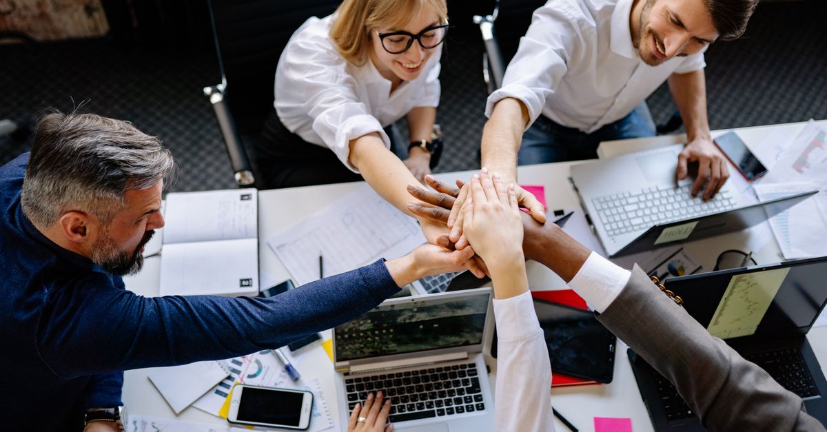 A group of professionals collaborating in a modern office, exemplifying teamwork and synergy.