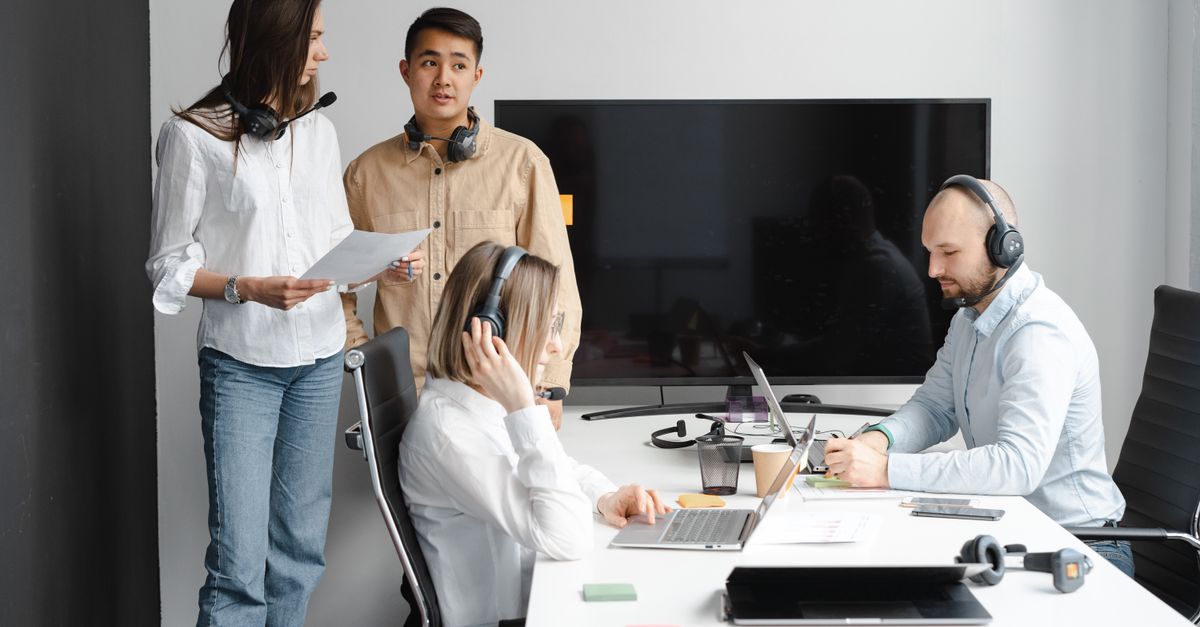Group of call center agents working together in a modern office setting.