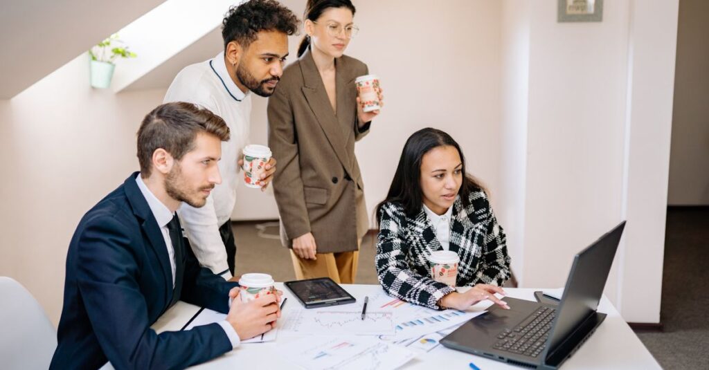 A diverse team collaborates in a modern office, using laptops and tablets for planning and brainstorming.