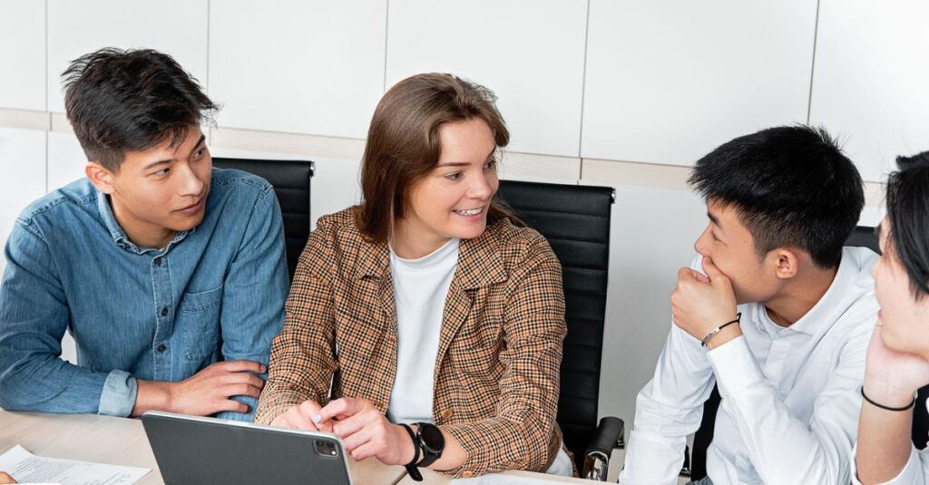 A group of young professionals engaged in a collaborative discussion at the office table.