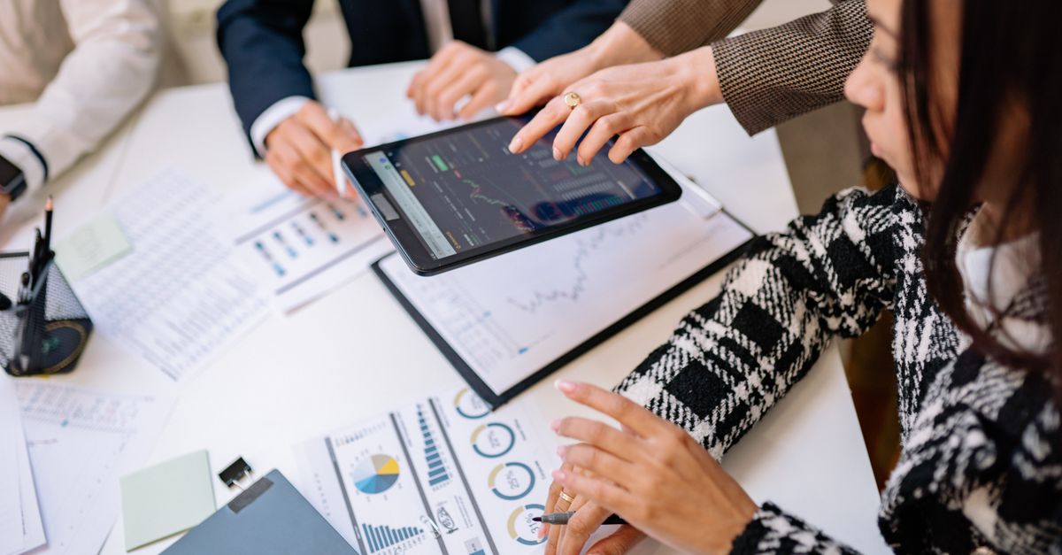 Business professionals reviewing analytics on a tablet during a meeting.