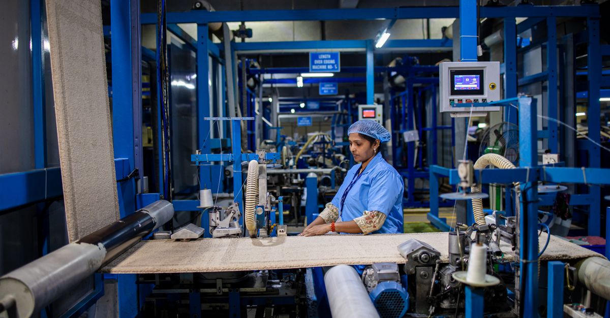 A textile factory worker operates machinery with precision, demonstrating industrial efficiency.