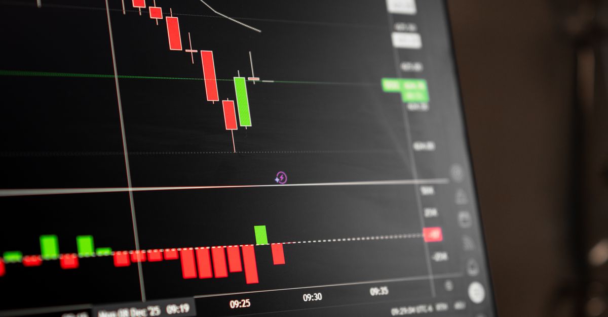 A close-up of a digital screen showing stock market candlestick chart data.