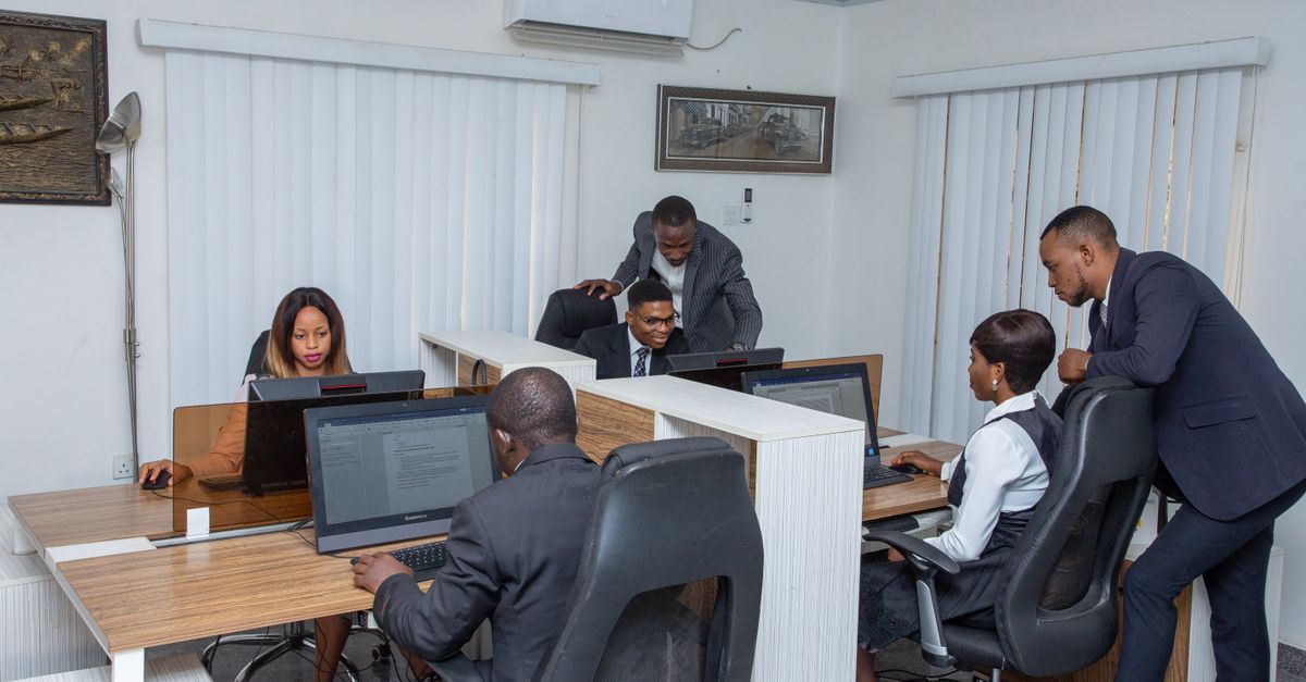 A group of professionals working together in a modern office setting, emphasizing teamwork and productivity.