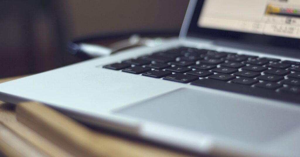 Focused image of a laptop keyboard on a table indoors, showing modern technology.