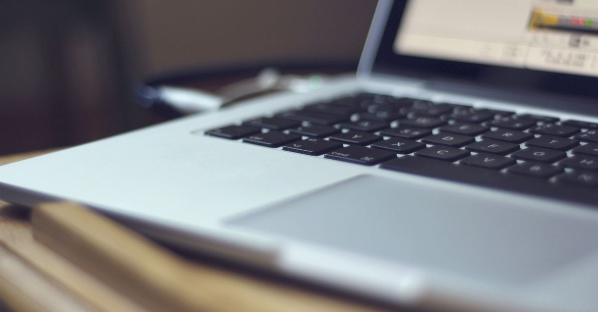 Focused image of a laptop keyboard on a table indoors, showing modern technology.