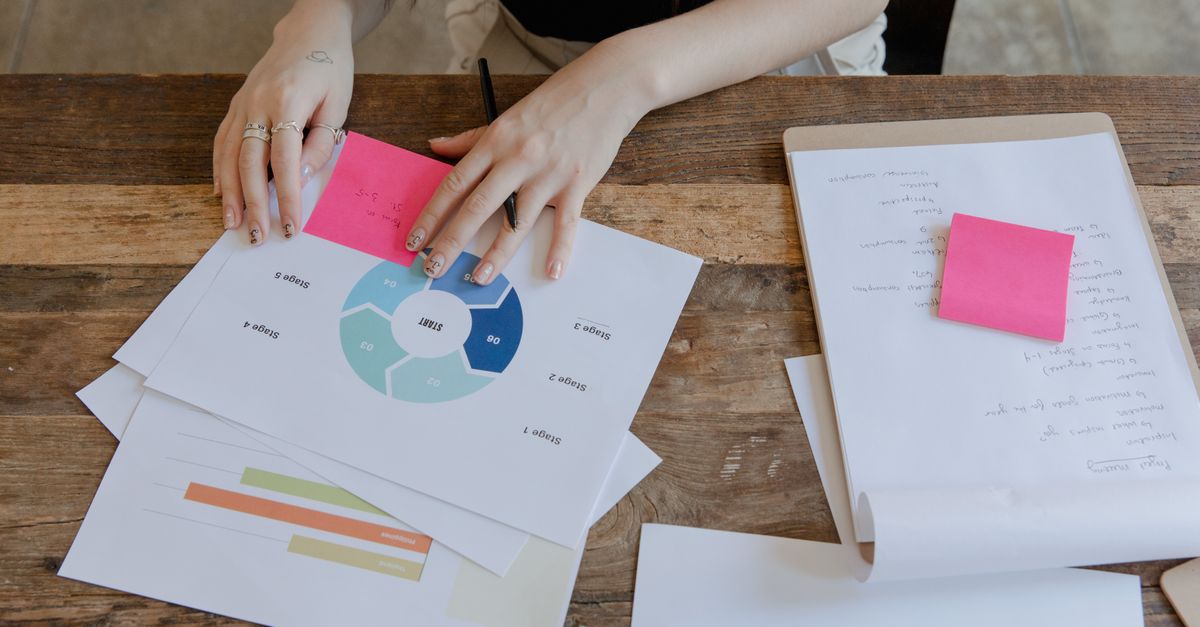 Overhead view of a workspace featuring data charts and sticky notes for business planning.