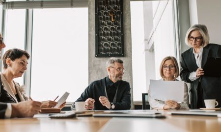 Business professionals discussing documents in a modern meeting room.