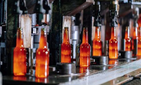 Glass bottles on a production line in a modern glass factory, showcasing industrial automation.