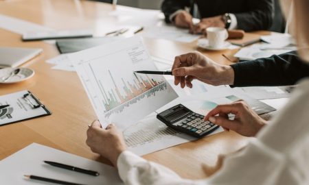 Professionals reviewing financial graphs and charts during a meeting.