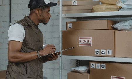 Courier checking packages in a warehouse, ensuring fragile handling