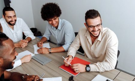 A group of diverse professionals collaborating during a team meeting in a modern office setting.