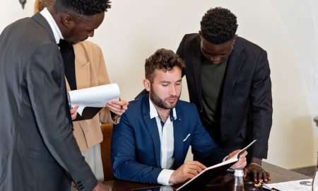 A diverse team collaborating in an office meeting, focusing on documents and teamwork.