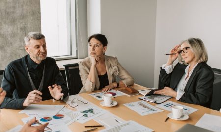 Diverse group of business professionals in a strategic meeting discussing documents and charts.