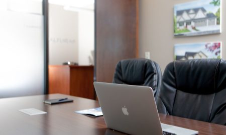 Sleek modern office interior featuring a laptop and art decor for a professional workspace.