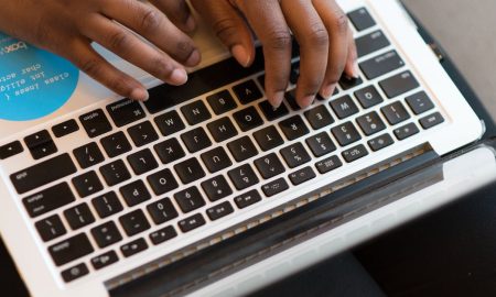 Close-up of hands typing on a laptop, showcasing modern technology and connectivity.
