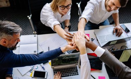 A group of professionals collaborating in a modern office, exemplifying teamwork and synergy.