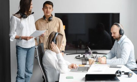 Group of call center agents working together in a modern office setting.