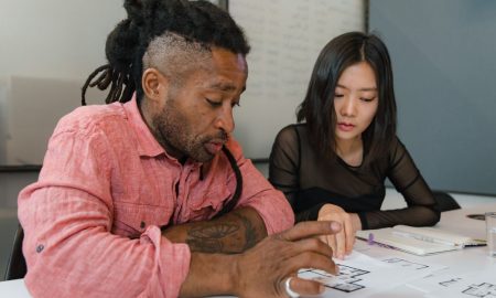 Two professionals engaged in planning during a business meeting, focusing on architectural designs.
