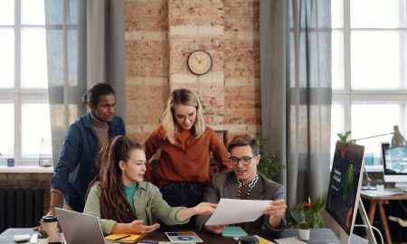 A diverse team of young professionals working on a business strategy in an urban office setting.