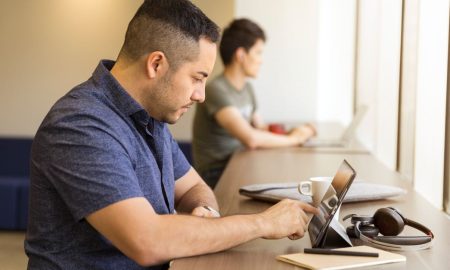 Two men working on devices in a modern office setting, emphasizing technology and collaboration.
