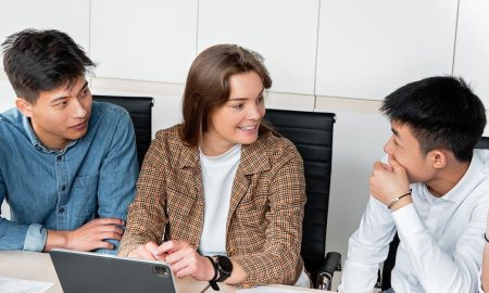 A group of young professionals engaged in a collaborative discussion at the office table.