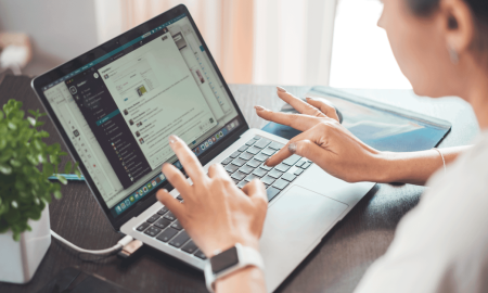 A woman working on a laptop from home, focusing on digital tasks and communication.