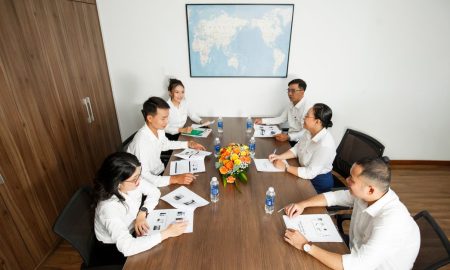 Group of professionals having a strategic business meeting at a conference table in a modern office setting.