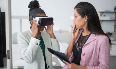 Two professional women collaborating using VR technology in a modern office setting, showcasing innovation.
