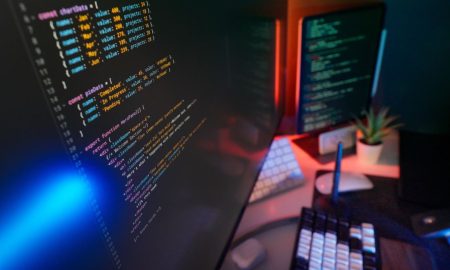 A vibrant workspace featuring colorful code on computer monitors, ideal for developers.