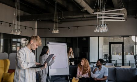 A diverse group of professionals collaborating during a business meeting in an open-plan office.