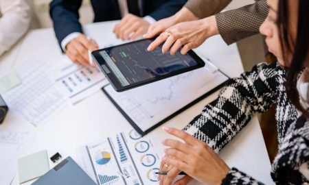 Business professionals reviewing analytics on a tablet during a meeting.