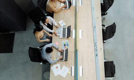 High angle view of colleagues working together on laptops in a modern office setting.