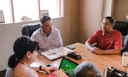 Colleagues discuss ideas in an office setting, emphasizing teamwork.