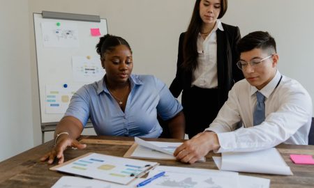 A diverse team discusses business strategies and processes in a modern office space.