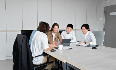 Diverse team of business professionals collaborating over a tablet in a modern office setting.