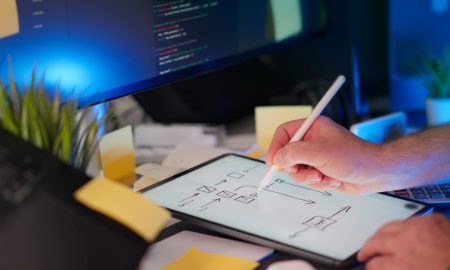 A vibrant workspace featuring digital sketching on a tablet and code on a monitor, showcasing a tech-savvy environment.