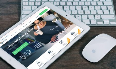 A tablet with a financial website open, alongside a white keyboard and mouse. Ideal for tech-theme stock images.