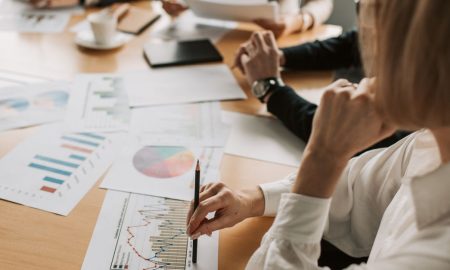 Business professionals reviewing charts and graphs during a meeting in office setting.
