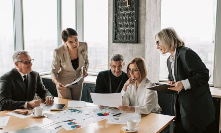 Business professionals engage in an office meeting to analyze data and strategies.