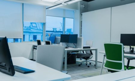 Bright and modern office environment with computer workstations and large windows.